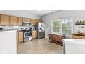 A bright kitchen features wooden cabinets, stainless steel appliances, and adjacent dining space at 5619 Payne Blvd, Plainfield, IN 46168