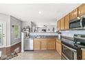 An inviting kitchen with stainless steel appliances, wood cabinetry, and a view into the adjoining living space at 5619 Payne Blvd, Plainfield, IN 46168