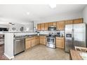 Well-lit kitchen showcases stainless steel appliances, wooden cabinets, and an open layout to the living area at 5619 Payne Blvd, Plainfield, IN 46168
