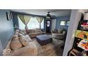 Inviting living room featuring a comfortable sectional couch, ceiling fan, and ample natural light at 5805 S Gale St, Indianapolis, IN 46227
