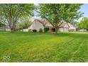 Beautifully landscaped yard surrounds this home with mature trees and lush green grass at 6034 Doverton Dr, Noblesville, IN 46062