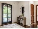 Welcoming foyer with a stylish console table, an oval mirror, and elegant hardwood floors, and a view to outdoors at 7601 W Stonegate Dr, Zionsville, IN 46077