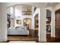 Spacious living room with high ceilings, hardwood floors, a fireplace, and an open layout with elegant archways at 7601 W Stonegate Dr, Zionsville, IN 46077