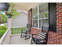 Inviting front porch with comfortable rocking chairs and striped pillows showcasing the home's exterior details at 764 Bloor Woods Ct, Zionsville, IN 46077