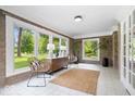 Bright sunroom featuring stone walls, tile floors, and large windows overlooking the landscaped yard at 8100 N Meridian St, Indianapolis, IN 46260