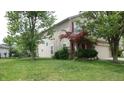Well maintained 2-story home with a green lawn and mature trees surrounding the property at 8160 Whitham Dr, Indianapolis, IN 46237