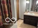Bathroom with a vanity, sink, and decorative mirror near the stairway at 8835 Winding Ridge Rd, Indianapolis, IN 46217