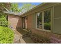 Home entrance features brick exterior, a well-kept garden, and a charming doorway with glass windows at 8909 Ellington Dr, Indianapolis, IN 46234