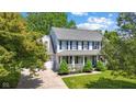 Charming two-story home with blue shutters and a welcoming front porch surrounded by mature trees at 10172 Watkins Ct, Indianapolis, IN 46234