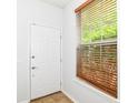 Bright foyer featuring a white door, wood-look blinds, and neutral decor at 1030 Longwell Pl, Indianapolis, IN 46240