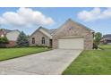 Well-maintained brick home with a two-car garage, concrete driveway, and a beautifully landscaped front yard at 105 Meadowview Ln, Greenwood, IN 46142