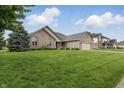 Beautifully landscaped front yard complements this brick home with an attached two-car garage and inviting facade at 105 Meadowview Ln, Greenwood, IN 46142