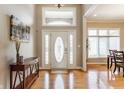 Inviting foyer featuring hardwood floors, a decorative front door, and ample natural light at 10784 Giselle Way, Fishers, IN 46040