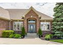 Elegant brick home entrance with a beautiful arched entryway and professionally landscaped surroundings at 10784 Giselle Way, Fishers, IN 46040