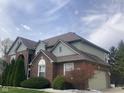 Well-maintained home shows siding and brick with mature landscaping and attached garage at 11458 Sutton Place W Dr, Carmel, IN 46032