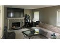 Cozy living room features a fireplace with stone surround and ample natural light from large windows at 11458 Sutton Place W Dr, Carmel, IN 46032
