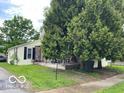 A nice home on a corner lot, partially obscured by mature trees at 121 W Fordice St, Lebanon, IN 46052