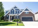 Charming brick and blue home exterior with a well-maintained lawn and an attached garage at 12600 Misty Ridge Ct, Fishers, IN 46037