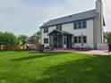 Expansive backyard with a large patio, screened-in porch, comfortable seating, and lush green lawn for outdoor enjoyment at 13497 Dunes Dr, Carmel, IN 46032