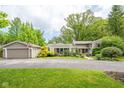 Well-maintained home with a detached garage and a lush, green lawn, offering curb appeal at 140 Meridian Hills Blvd, Indianapolis, IN 46260