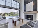 Bright living room with soaring ceilings, large windows, fireplace, and open access to the backyard pool at 14464 Gainesway Cir, Fishers, IN 46040