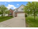 Traditional home with a brick and vinyl facade, featuring a two-car garage and well-kept front lawn at 14542 Baldwin Ln, Carmel, IN 46032