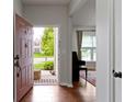 Welcoming entryway with hardwood floors leading to a living area, showcasing a bright and airy atmosphere at 14542 Baldwin Ln, Carmel, IN 46032