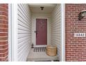 Inviting front entry featuring a covered porch, brick accents, and a decorative door with stylish accents at 14542 Baldwin Ln, Carmel, IN 46032