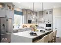 Modern kitchen with gray cabinets, stainless steel appliances, a large center island, and pendant lighting at 19848 Chatsworth Blvd, Westfield, IN 46074