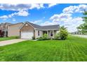 Well-kept home on a corner lot featuring a lush green lawn, mature trees and an attached two-car garage at 2201 Schoolmarm Dr, Greenfield, IN 46140