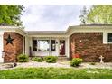 Charming brick home with a well-manicured front yard, tasteful decor and a red front door at 2965 E 1100 N, Pendleton, IN 46064
