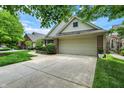 View of the two-car garage and wide driveway of a single-Gathering home in a suburban neighborhood at 3033 Daum Ct, Carmel, IN 46033