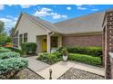 Inviting front porch with a bright yellow door, decorative wreath, and charming flower pots at 3033 Daum Ct, Carmel, IN 46033