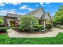 View of the front yard and entrance of a single Gathering home with mature trees and lush landscaping at 3033 Daum Ct, Carmel, IN 46033