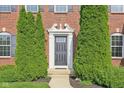 Inviting front entrance framed by symmetrical evergreen shrubs, and decorative trim, offering a welcoming curb appeal at 3267 Cimmaron Ash Ct, Zionsville, IN 46077