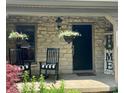 Inviting front porch with stone accent, rocking chairs, and hanging flower baskets adding to curb appeal at 3559 S County Road 475 E, Plainfield, IN 46168