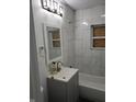 Modern bathroom with new marble-style tiling, vanity, and updated fixtures at 3644 N Parker Ave, Indianapolis, IN 46218