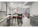Bright dining room with a ceiling fan, access to the backyard and granite countertops on the kitchen island at 3702 N Chester Ave, Indianapolis, IN 46218