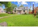 Charming stone house with a well-manicured lawn and inviting front porch and a traditional walkway to the front door at 3702 N Chester Ave, Indianapolis, IN 46218