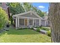 This cozy single-story house has a covered front porch, gray siding, and an inviting front yard at 4359 Winthrop Ave, Indianapolis, IN 46205