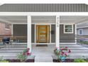 Welcoming covered front porch featuring a modern wood door and classic exterior design details at 4359 Winthrop Ave, Indianapolis, IN 46205