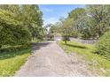 Long driveway leading to a well-maintained home surrounded by lush greenery and mature trees at 4622 S Franklin Rd, Indianapolis, IN 46239