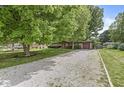 Traditional single Gathering home with a long gravel driveway and mature landscaping in a serene, wooded setting at 5427 Heights Ave, Indianapolis, IN 46237