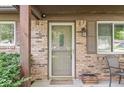 Inviting brick front porch featuring a screen door, shuttered windows, and a decorative wooden beam accent at 5427 Heights Ave, Indianapolis, IN 46237