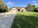 Inviting single-Gathering home featuring a well-manicured lawn, mature trees, and a long driveway at 6143 Roberts Pl, Indianapolis, IN 46220