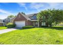 Charming two-story home featuring brick accents, attached garage, and well-manicured lawn at 7587 Winding Way, Fishers, IN 46038