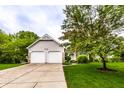 Traditional home showcasing a two-car garage, neutral siding, and a lush front yard, perfect for Gathering living at 9118 Hardwood Ct, Indianapolis, IN 46250