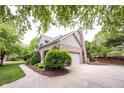 Side view of a home featuring a brick exterior, attached garage, and landscaped garden at 9127 Pointe Ct, Fishers, IN 46037