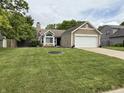 Charming one-story home boasts manicured lawn, stone accents, and an attached two-car garage at 9277 Embers Way, Indianapolis, IN 46250