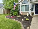 Well maintained landscaping, complete with mulch bed and rock border, surrounds the front of the house at 9277 Embers Way, Indianapolis, IN 46250